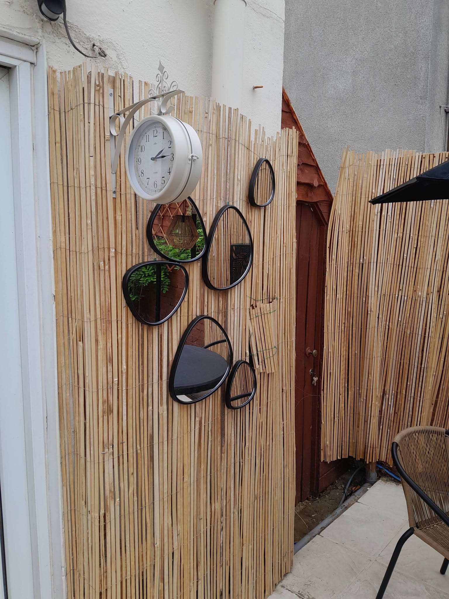 Bamboo wall with decorative mirrors and wall clock