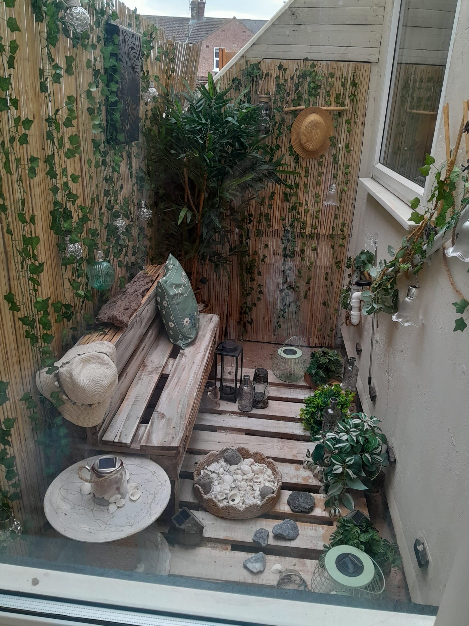 Cosy garden retreat with pallet seating and greenery